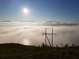 heavy fog over tromsoe city island and tromsdalen mainland in northern norway with high voltage powerlines going into the dense fog