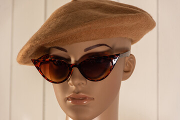 Female mannequin poses in the foreground for fashion photos with a Basque hat