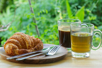 Thai Black Coffee and hot Tea with croissant bread on  Wooden Bar