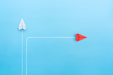 New normal concept with Red paper plane in new direction on blue background