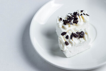 Two white marshmallows poured with white chocolate. marshmallows on a white plate. Dessert of the aristocrat.