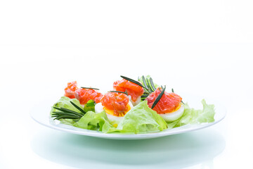 boiled eggs with salted red fish and salad leaves
