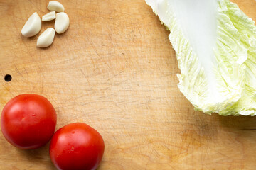 vegetables on a cutting board, tomatoes, cabbage and garlic for a vegetarian spring salad, healthy tasty food