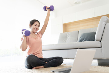 Fototapeta na wymiar Asian woman learning exercise from internet for self care workout at home during quarantine coronavirus or covid spread time