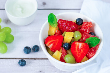Fruit salad of grapefruit, strawberries, kiwi, mango, grape and blueberry. Horizontal orientation