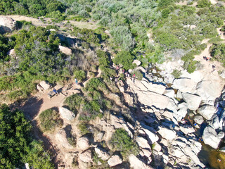 Aerial view of Los Penasquitos Canyon Preserve with the creek waterfall and people enjoying the water. Urban park with trails and river in San Diego, California. USA