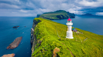 Gloomy view from flying drone of Mykines island with old lighthouse. Attractive morning scene of Faroe Islands, Denmark, Europe. Dramatic seascape of Atlantic ocean. Traveling concept background.. - obrazy, fototapety, plakaty