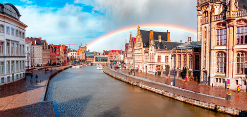 Ghent, Belgium, at sunset in spring with a rainbow. Historic city where you can see both Korenlei and Graslei as the river Lys (Leie) passes through the middle. Common place for tourists and students.