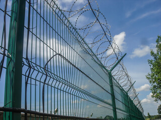 Fence with barbed wire on a guarded private territory.