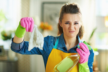 disgusted woman with cleaning agent showing dirty wet wipe