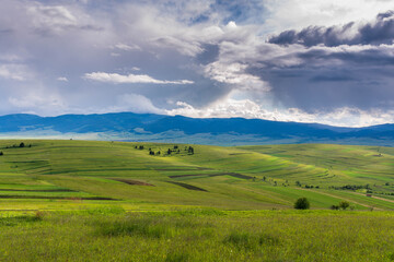 Fototapeta na wymiar Gathering storm clouds over green hills in the Carpathian mountains, Romania.