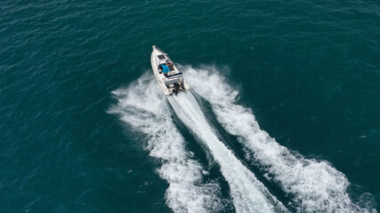Naklejka premium Aerial drone photo of inflatable boat cruising in high speed near Mediterranean port
