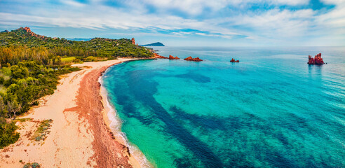 View from flying drone. Captivating summer view of di Cea beach with Red Rocks Gli Scogli Rossi - Faraglioni. Aerial morning scene of Sardinia island, Italy, Europe. 