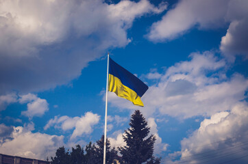 Large flag of Ukraine against the backdrop of clouds.