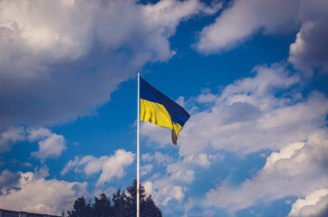 Large flag of Ukraine against the backdrop of clouds.
