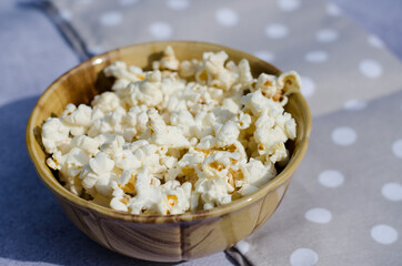 Popcorn in a brown bowl closeup side view.