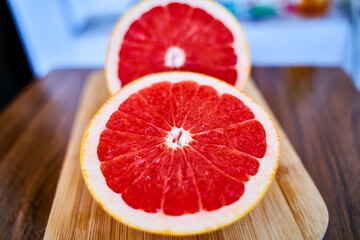 Half sliced red grapefruit on wooden table