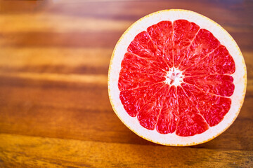 Half sliced red grapefruit on wooden table