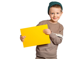 A handsome European boy with blue eyes holds a yellow sheet of paper on a white background, and smiles. Place for text, banner, surface for inscriptions and advertising.