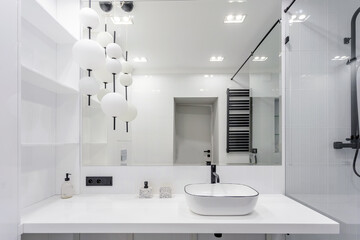 bright bright bathroom with a large washbasin mirror