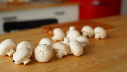 Close up of mushrooms on kitchen table. Small white mushrooms scattered on table in kitchen.