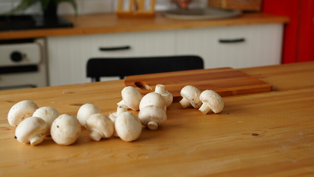 Close Up Of Mushrooms On Kitchen Table. Small White Mushrooms Scattered On Table In Kitchen.