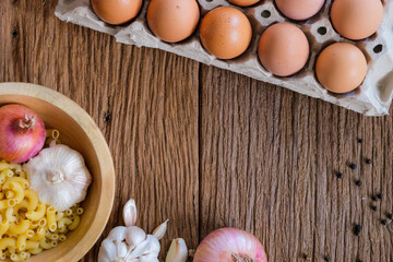 The view of the macaroni on the wooden background is a popular ingredient for cooking. There are many different shapes according to usage.