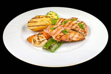 Delicious Chicken breast with grilled vegetables on a white plate, isolated on black background