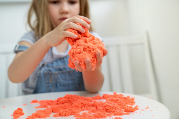 little girl playing with kinetic sand. development of fine motor skills. 