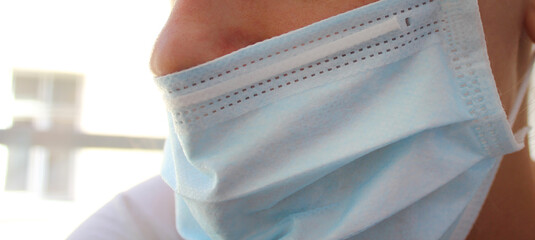 Medical face mask wrong usage. Caucasian unrecognisable man or woman wearing face mask without...