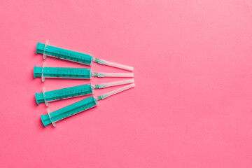 Top view of medical syringes on colorful background with copy space. Injection equipment concept