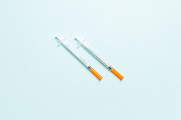 Top view of two insulin syringe at colorful background with copy space. High level of glucose...