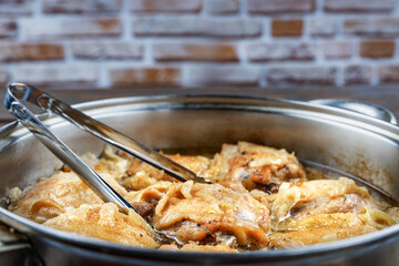 Chicken thighs fried in a pan, close-up, shallow depth of field, selective focus. Homemade food concept.