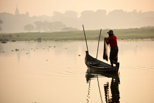 Local fisher man use fish net catch fish in Taungthaman lake near u-bein bridge, Mandalay, Myanmar (Burma)