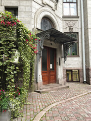 St. Petersburg, Russia - May 1, 2020, Beautiful front door with flowers in a stone house in the historical center of St. Petersburg