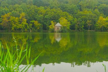 Tarrytown, New York, USA: A small stone building on the Tarrytown Reservoir, with early fall foliage in the background.