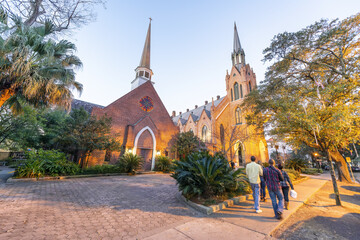 Tourists walking along the street in front of Methodist Church at night, New Orleans - obrazy, fototapety, plakaty