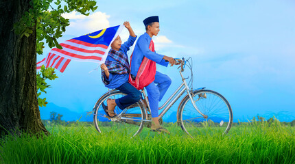 Independence Day concept - Two happy young local boy riding old bicycle at paddy field holding a...