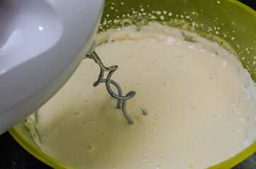 Electric mixer in a plate whips the dough