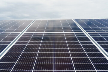 Solar cells closeup. Alternative solar panels power plant. Sustainability of planet. Green energy for home. Sun blue electric modules stands in row on the ground