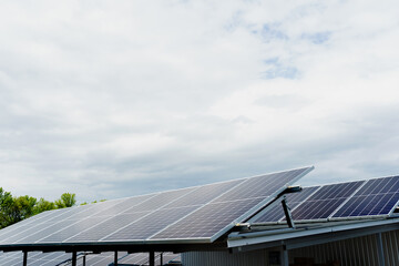Solar panels stands in row on the roof . Free electricity for home. Sustainability of planet. Green energy. Solar cells power plant business. Ecological clean energy. Blue panels on the ground.