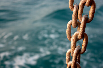 Chain and the sea. Chain close-up on the background of the sea at sunset. Sea waves in the evening out of focus.