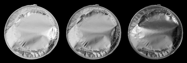 shiny round piece of plastic foil trash or garbage isolated on black under different light settings, silver chips packaging cap.