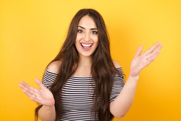 Cheerful woman making a welcome gesture raising arms over head isolated on white background.
