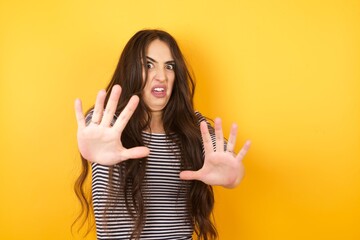 Dissatisfied female model frowns face, has disgusting expression, shows tongue, expresses non...