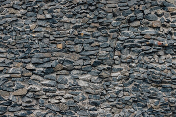 Stone wall. Detailed texture of a wall lined with cobblestones with cement.