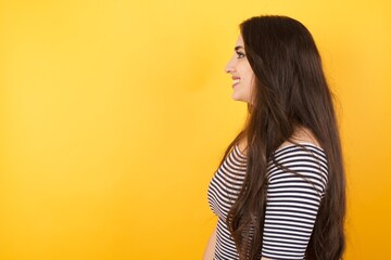 Profile of smiling woman with healthy pure skin, has contemplative expression, ready to have outdoor walk, isolated over white studio wall with copy space