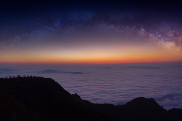 The silhouette of misty mountains and milky way