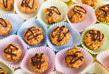 Small nut desserts in colored paper for a party with chocolate decoration