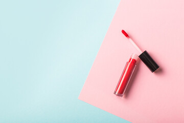 Red lip gloss on color background. Flat lay.